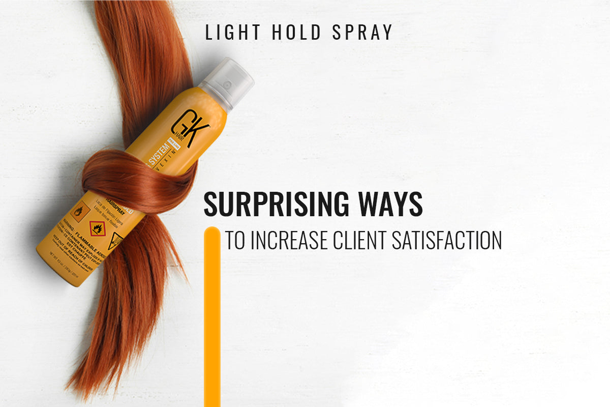Stylist spraying light hold hairspray onto a finished blowout in a salon