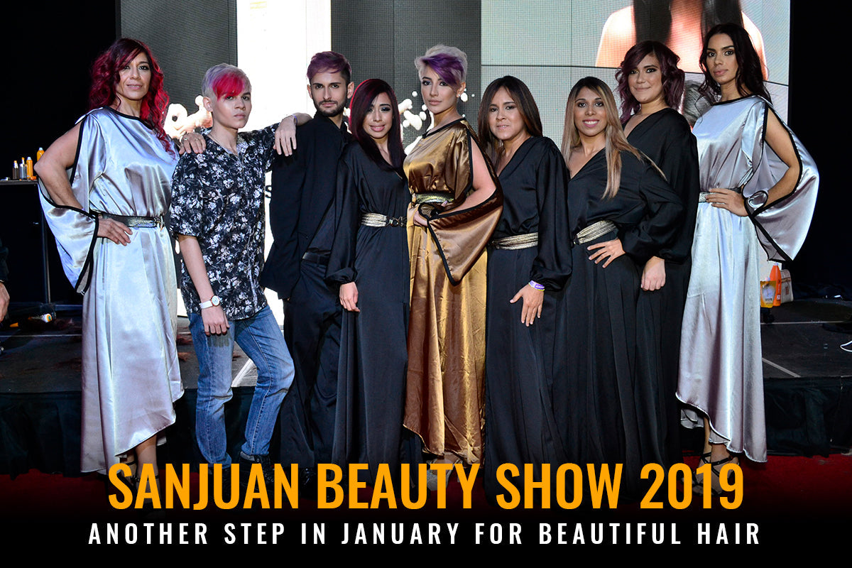 Group of stylists and models in black, silver and gold satin gowns posing on stage