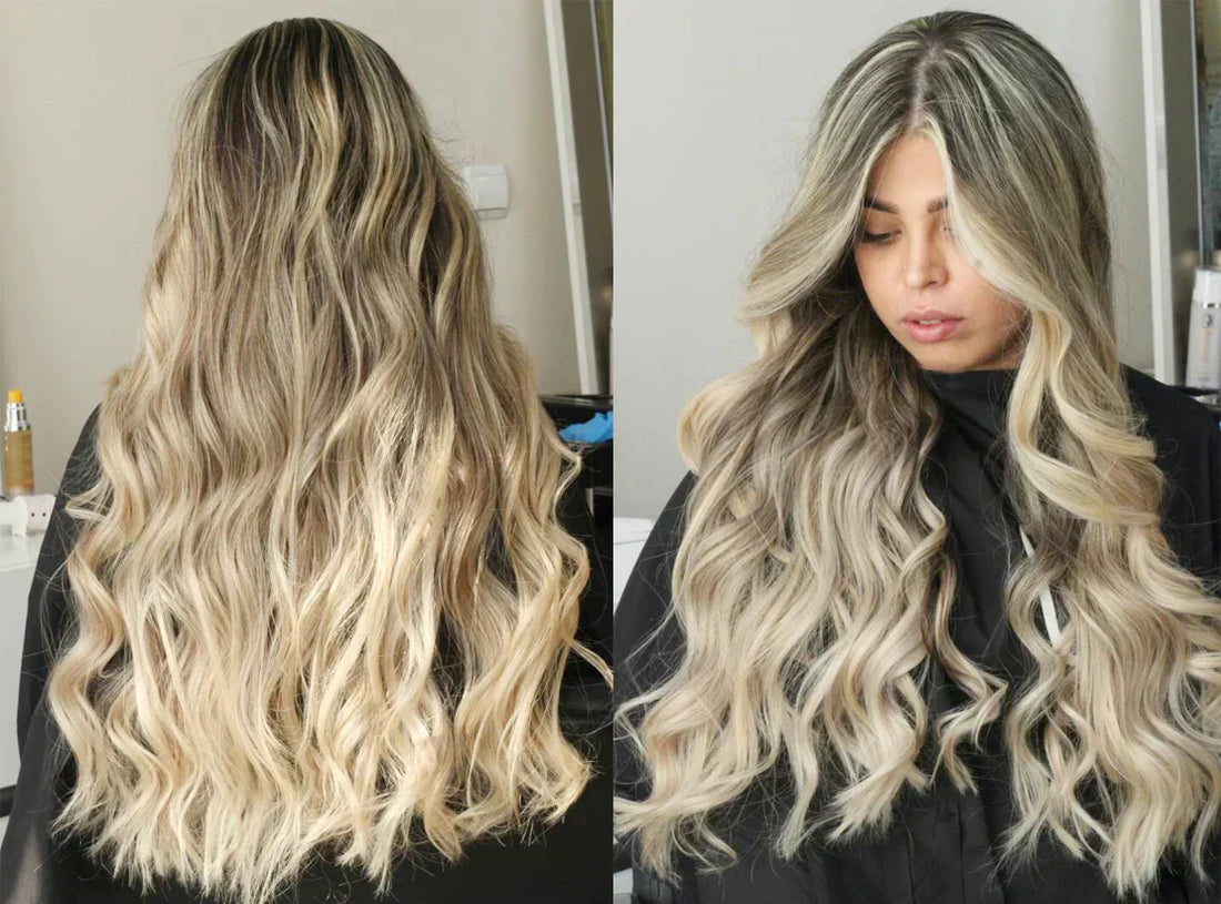 Long, wavy hair with pearl blonde highlights, styled elegantly, cascading down the back. The background features a neutral setting.