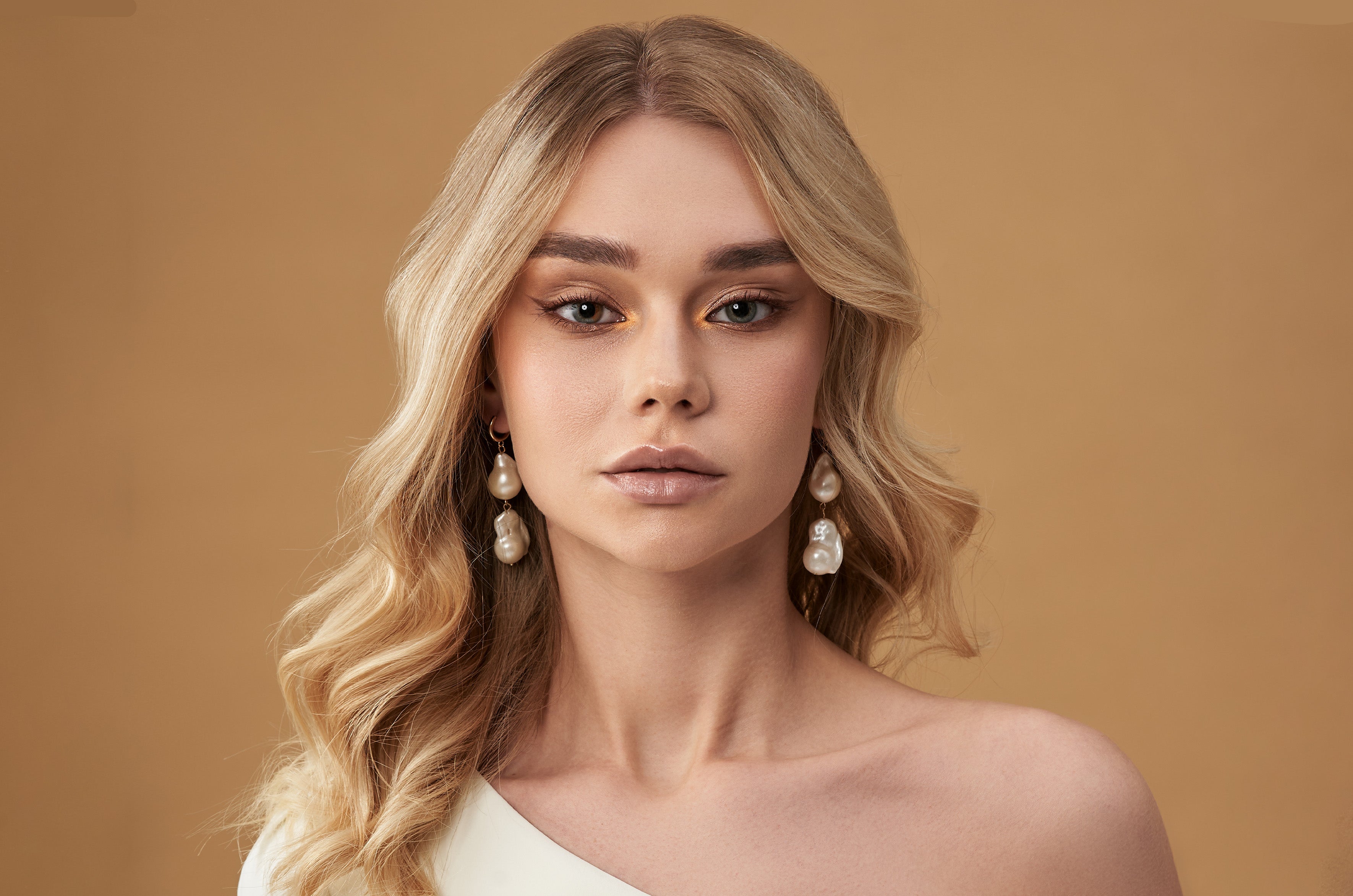 Woman with golden blonde wavy hair styled in a smooth blowout