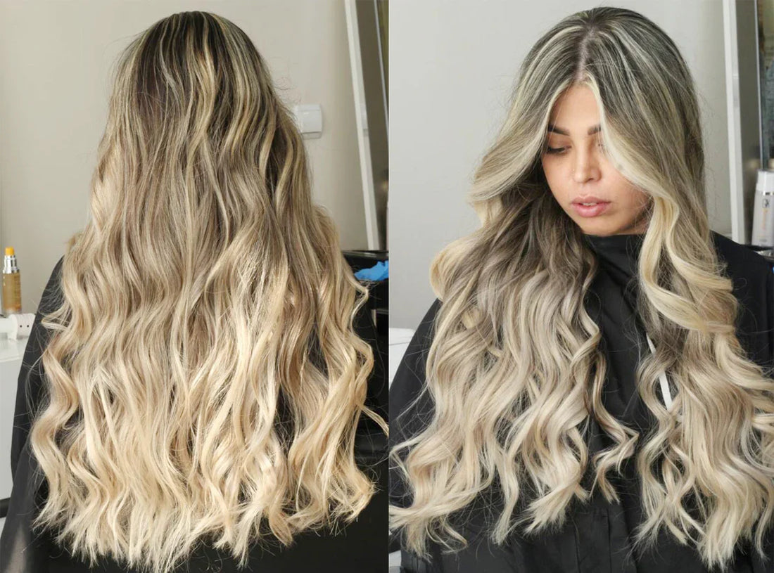 A close-up view of long, wavy hair with blonde highlights, cascading down the back, styled in loose, flowing curls.
