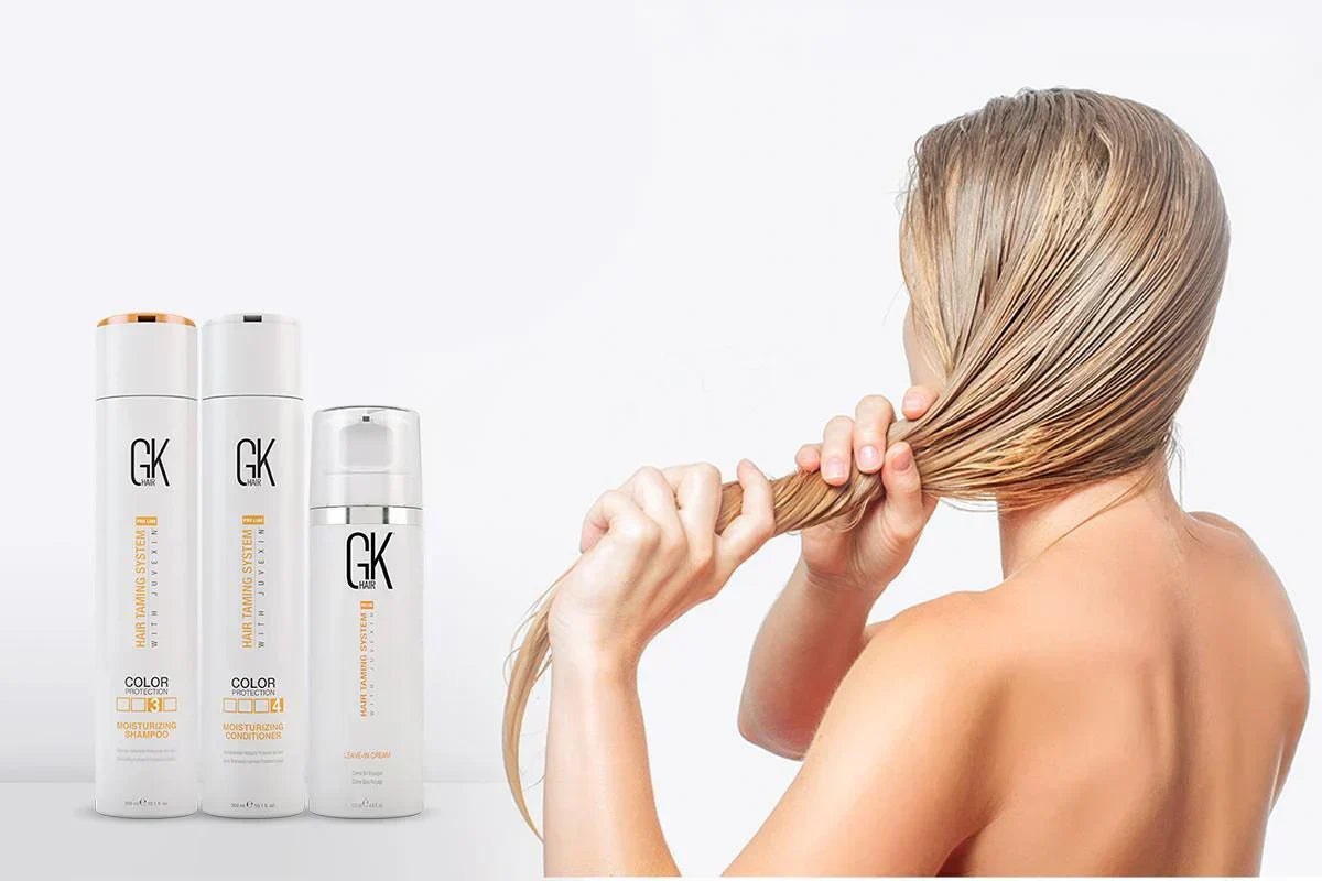 A woman with long, wet hair holds it in one hand, showcasing sleek and smooth texture. Beside her are three GK Hair products in sleek bottles.