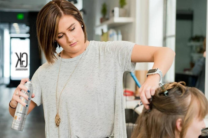 A female hair stylist using Vegan Hair Products on her client