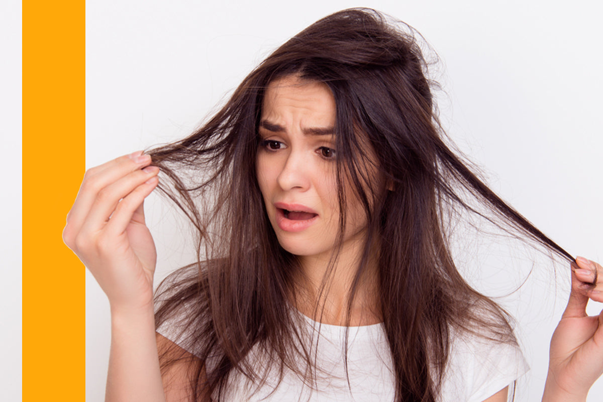 Lady unhappy looking at her dull, dry, and damaged hair