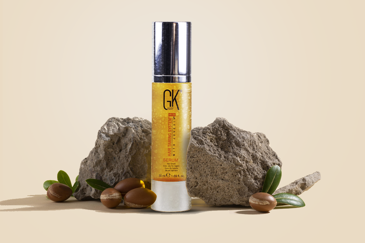 Dropper of nourishing hair oil held above the dry ends of long hair