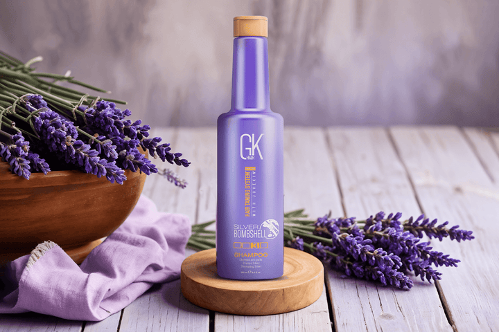 Purple shampoo being applied to wet blonde hair to neutralize brassy yellow tones