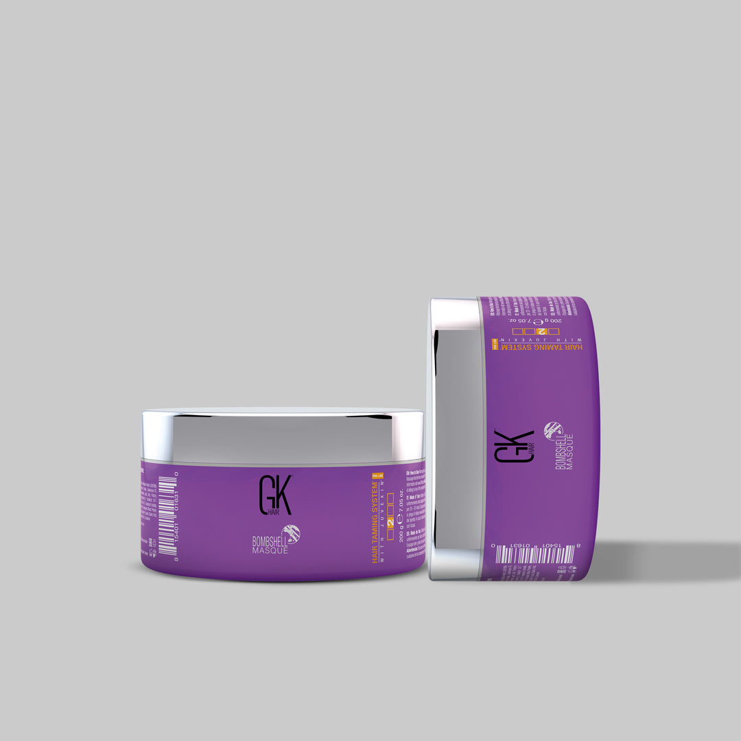 Two purple GK Hair Bombshell Masque jars with silver lids on a gray background, one standing on its side