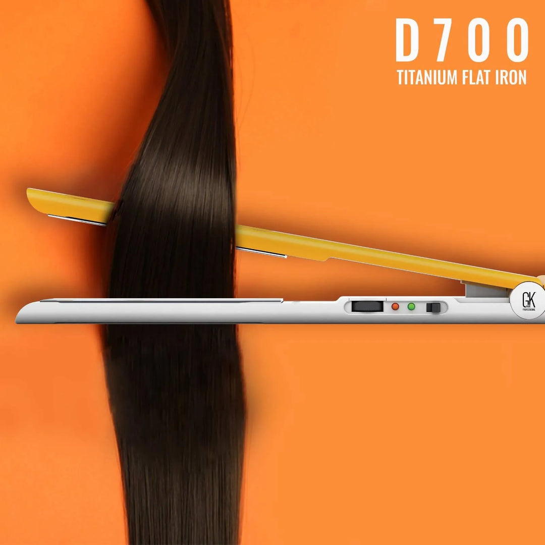 GK Hair D700 Titanium Flat Iron in white and yellow gliding down a long dark brown hair section on an orange background