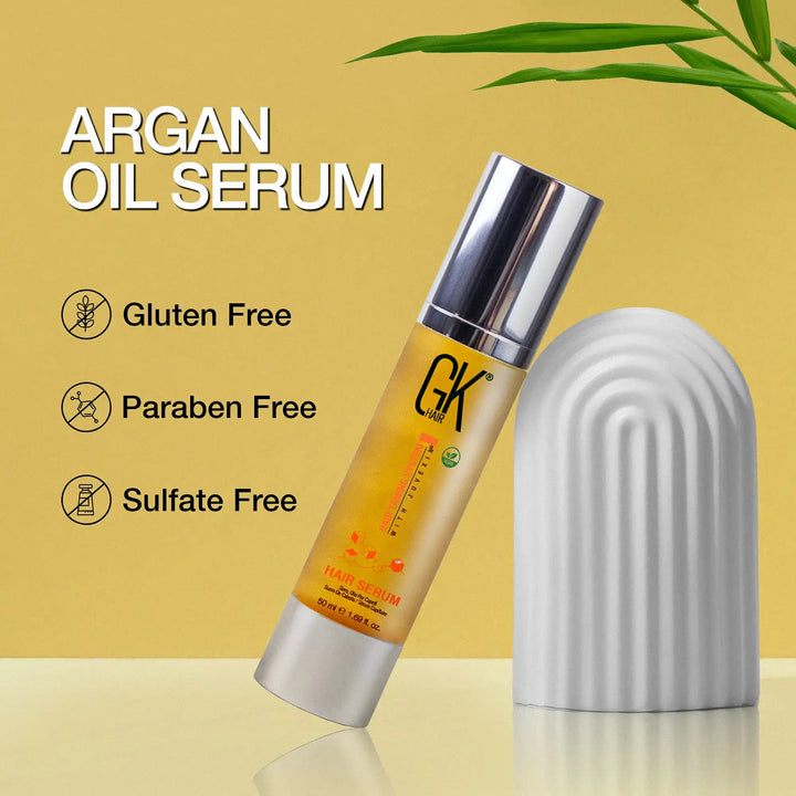 GK Hair Argan Oil Serum 50 ml bottle leaning on a white arch prop, with Gluten Free, Paraben Free and Sulfate Free icons