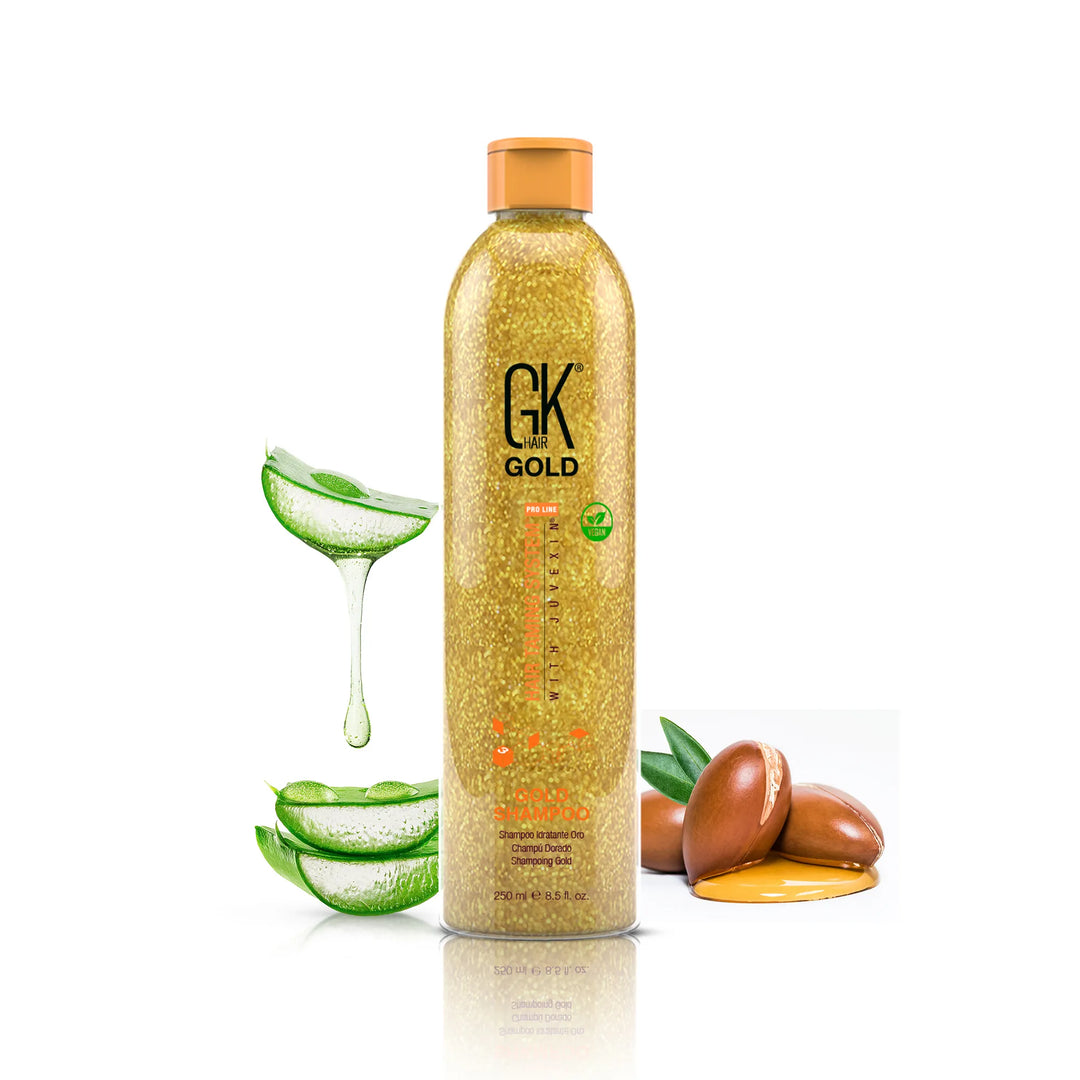 GK Hair Gold Shampoo 250 ml gold glitter bottle with an orange cap, aloe vera and dripping argan nuts on white