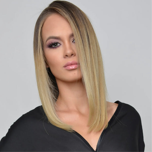 Studio portrait of a model with a sleek shoulder-length blonde lob, dark roots, plum smoky eyes and a black top