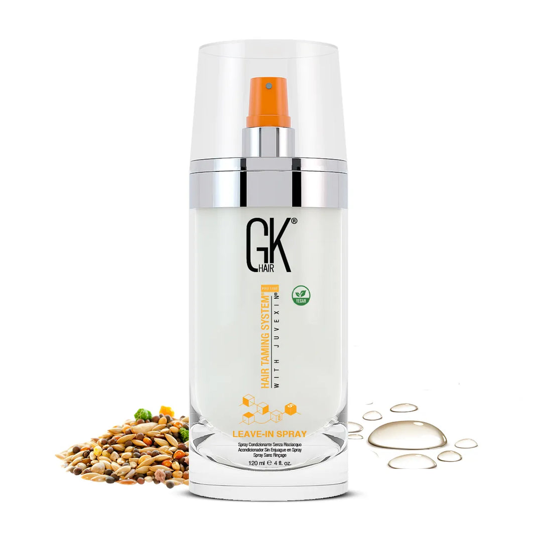 GK Hair Leave-In Spray 120 ml clear pump bottle with an orange nozzle, vegan badge, seeds and oil drops at its base