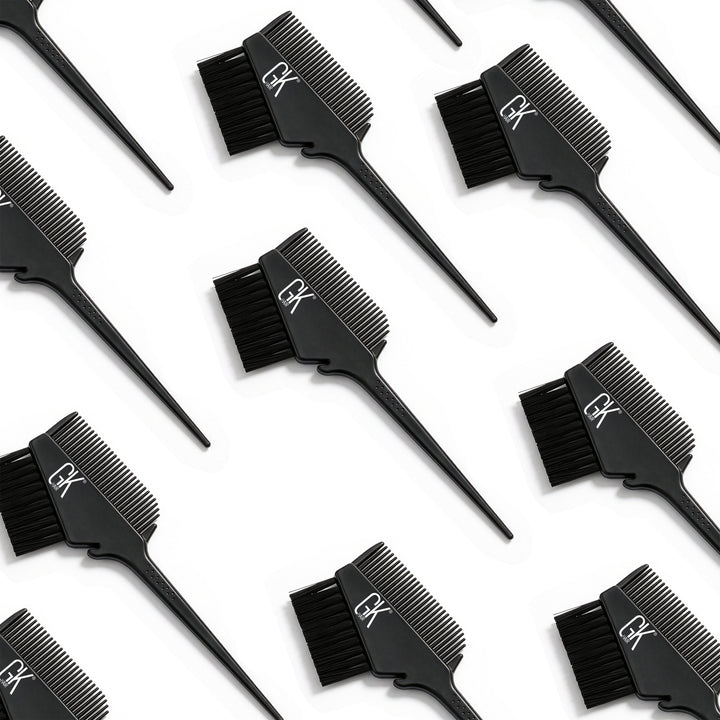 Rows of black GK Hair brush-and-comb applicators laid diagonally on white