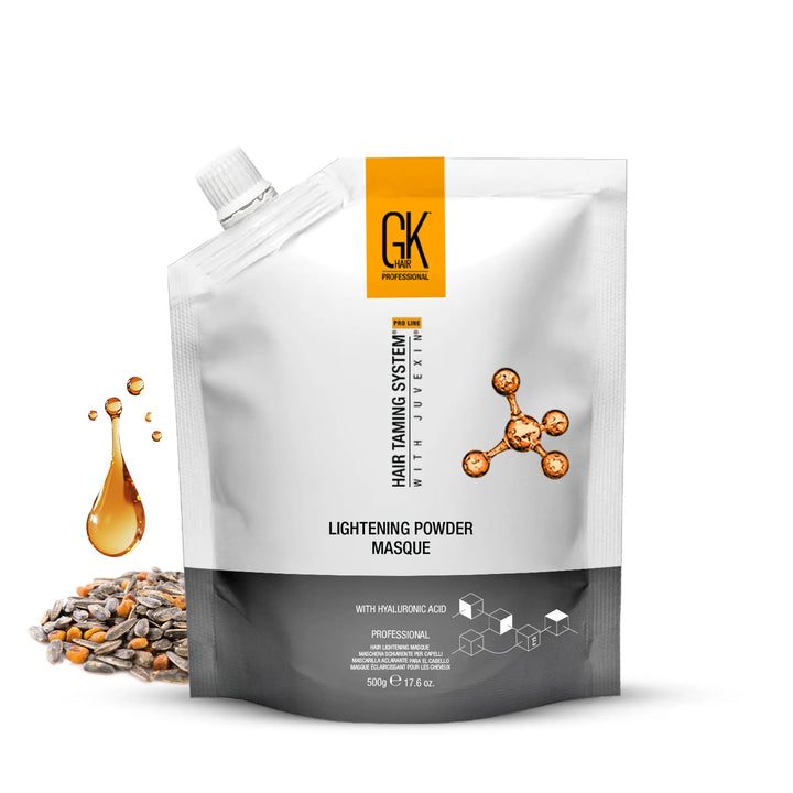 GK Hair Lightening Powder Masque pouch, 500 g / 17.6 oz, beside an amber oil droplet and sunflower seeds on white