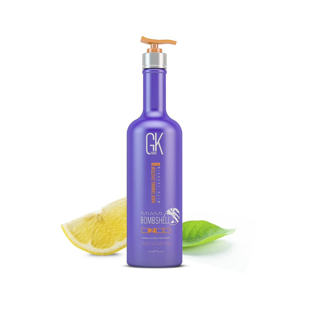 GK Hair Miami Bombshell Taming Blonde Treatment 710 ml purple bottle with an orange pump, beside a lemon slice and green leaf