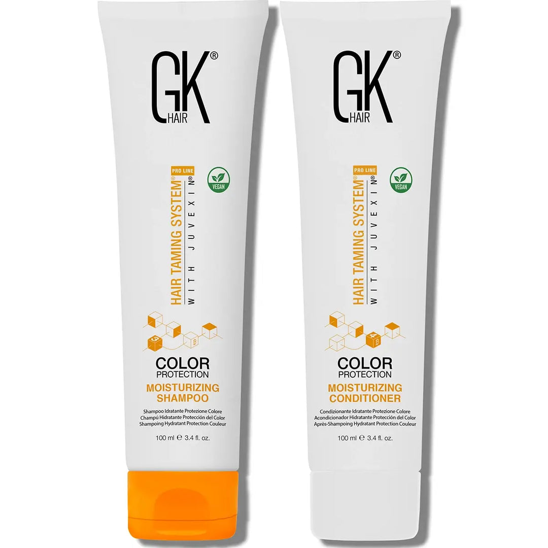 Two GK Hair moisturizing shampoo and conditioner bottles on a white background