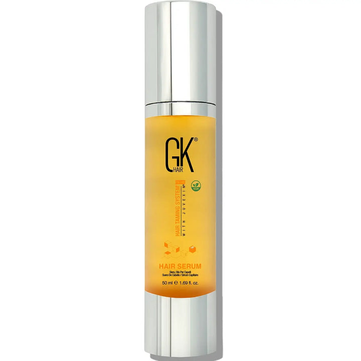 Hair serum bottle with silver cap and yellow label on a white background