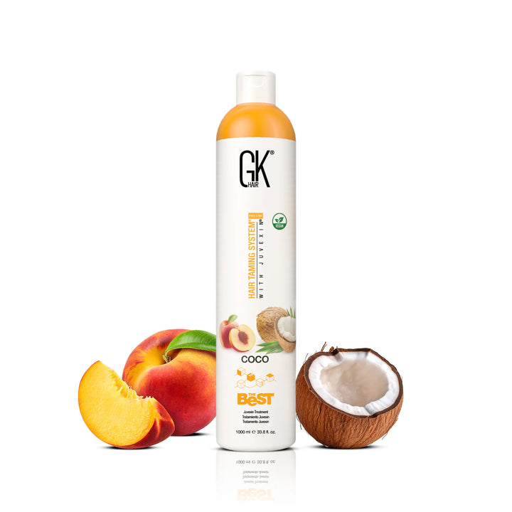 GK Hair The Best Coco Juvexin Treatment 1000 ml white bottle with orange cap, between a peach and half a coconut