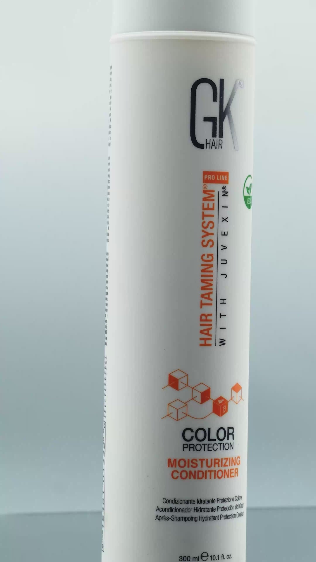 GK Hair Color Protection Moisturizing Shampoo and Conditioner 300 ml beside the Juvexin Serum and a wooden comb on black