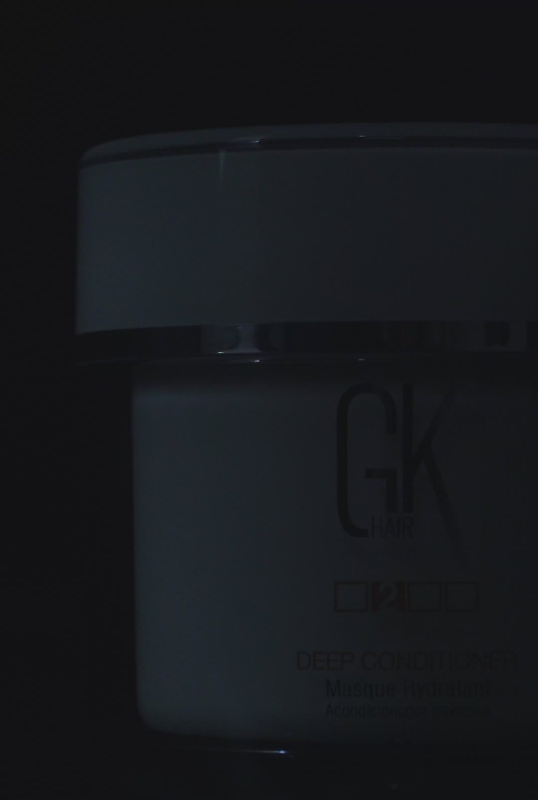 GK Hair Deep Conditioner masque jar in close crop on black, open lid revealing rich white cream and a metal spatula